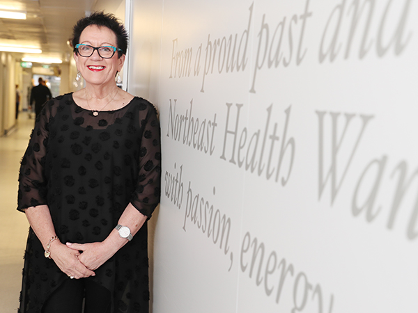 Margaret stands next to her motto, clearly enscrubbed on the memorial wall celebrating 140 years, “From a proud past and with ﬁrm foundations, Northeast Health Wangaratta faces the future with passion, energy, vision and optimism.”