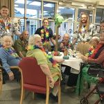 Residents and staff enjoying Hawaiian themed Happy Hour