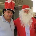 Santa standing next a gentleman with a hat that looks like a chimney