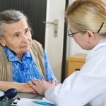 medical staff holding residents hand in a reassuring way