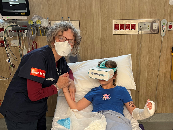 female nurse with young patient who is wearing the Smileyscope virtual reality headset. 